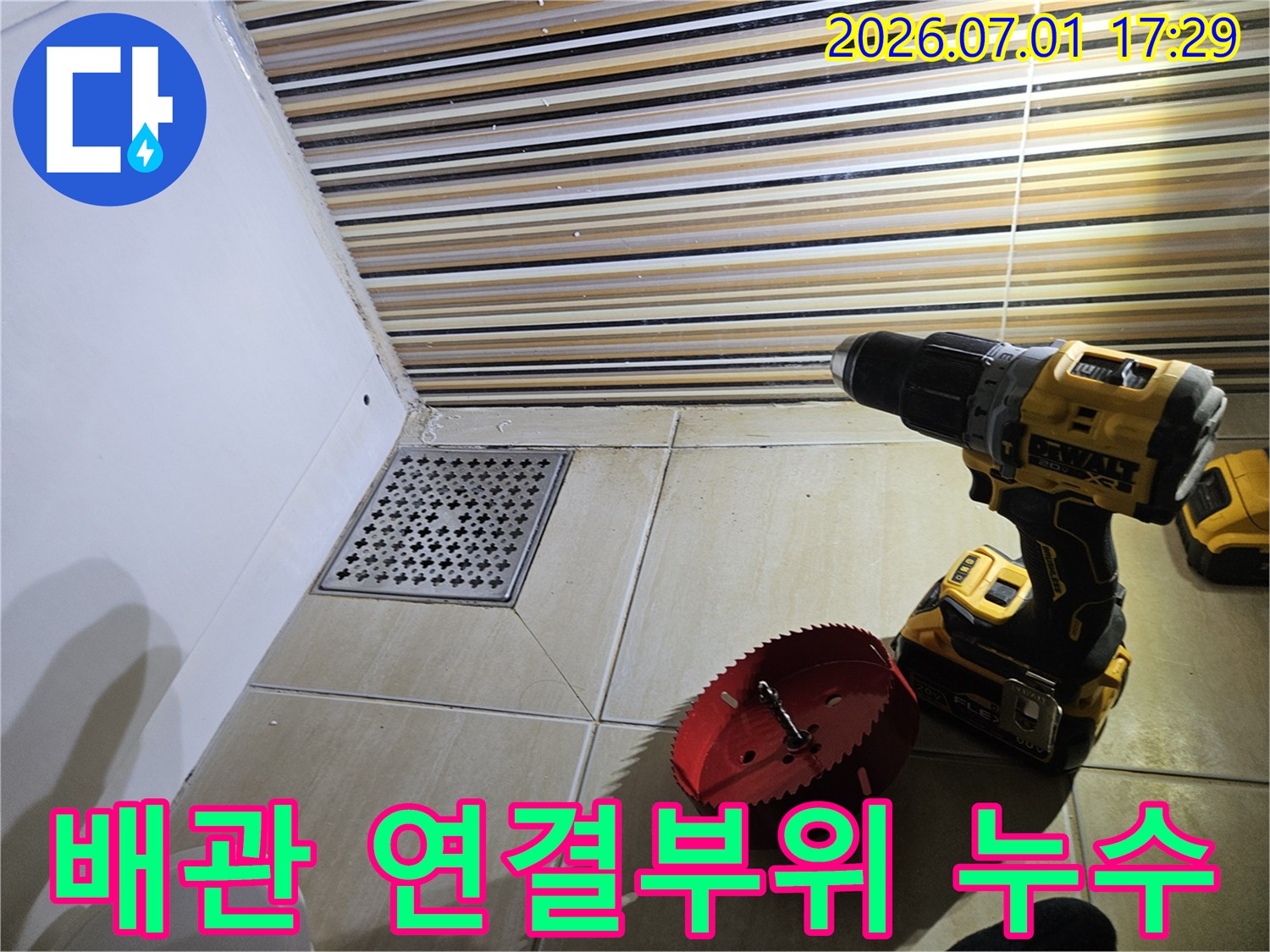 욕실 바닥 배수구 주변에서-배관 연결부위 누수를 탐지하고-수리 작업을 위해-드릴과 홀쏘를 준비하는 현장입니다