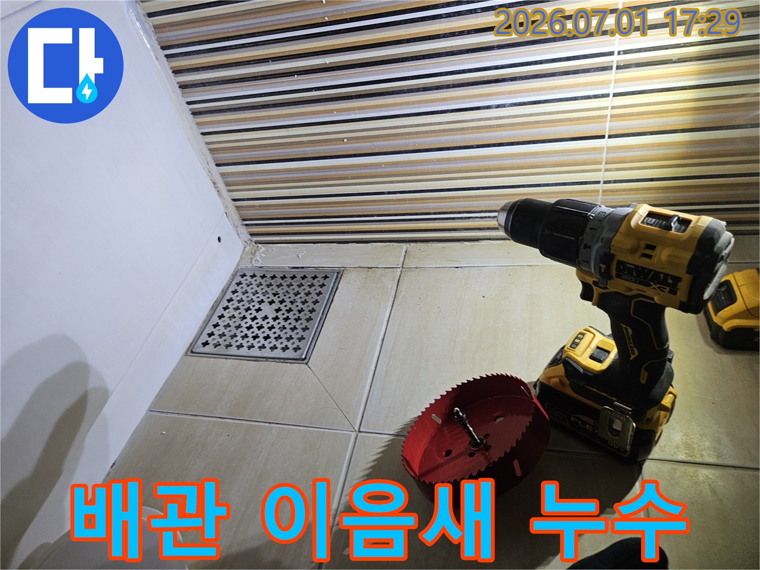 욕실 바닥 배수구 주변에서-배관 이음새 누수를 탐지하고-수리 작업을 위해-드릴과 홀쏘를 준비하는 현장입니다