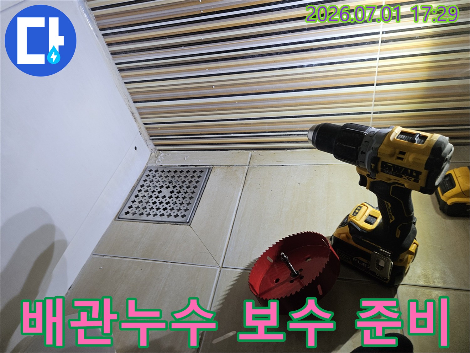 욕실 배수구 주변에서-배관 누수를 탐지하고-정확한 수리를 위해-타일 절단용 장비를 준비하는 장면입니다