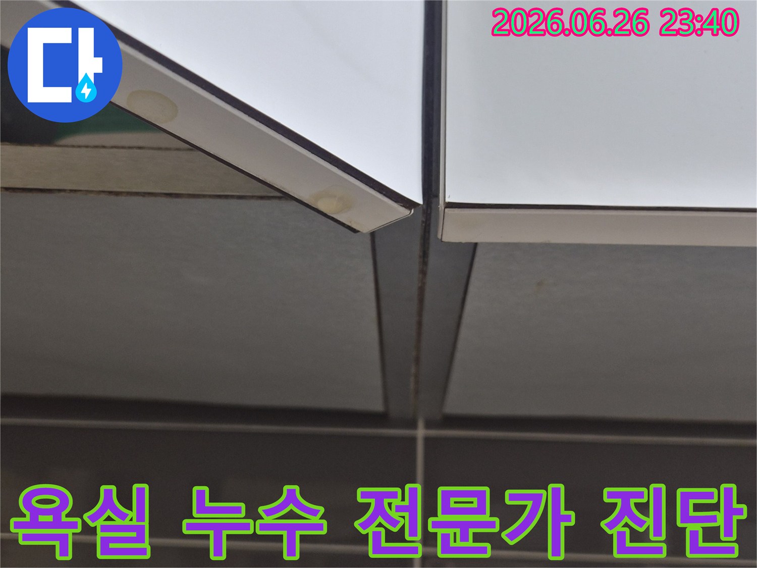 욕실-타일-틈새에서-발견된-누수-흔적을-전문가가-면밀히-진단하고-있는-모습을-담은-사진
