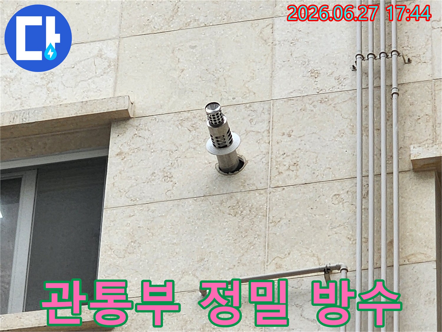 건물 외벽에 설치된 관통부 주변의 마감 상태를 정밀하게 점검하고 방수 시공을 준비하는 모습