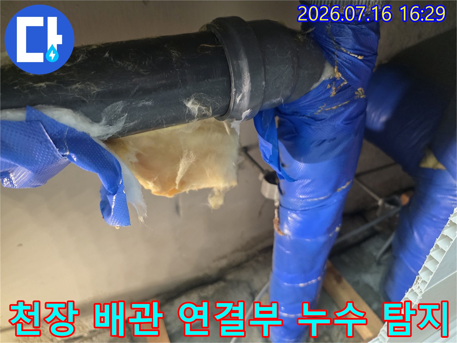 노후된 파이프 연결부와 훼손된 단열재가 있는 천장 내부 모습