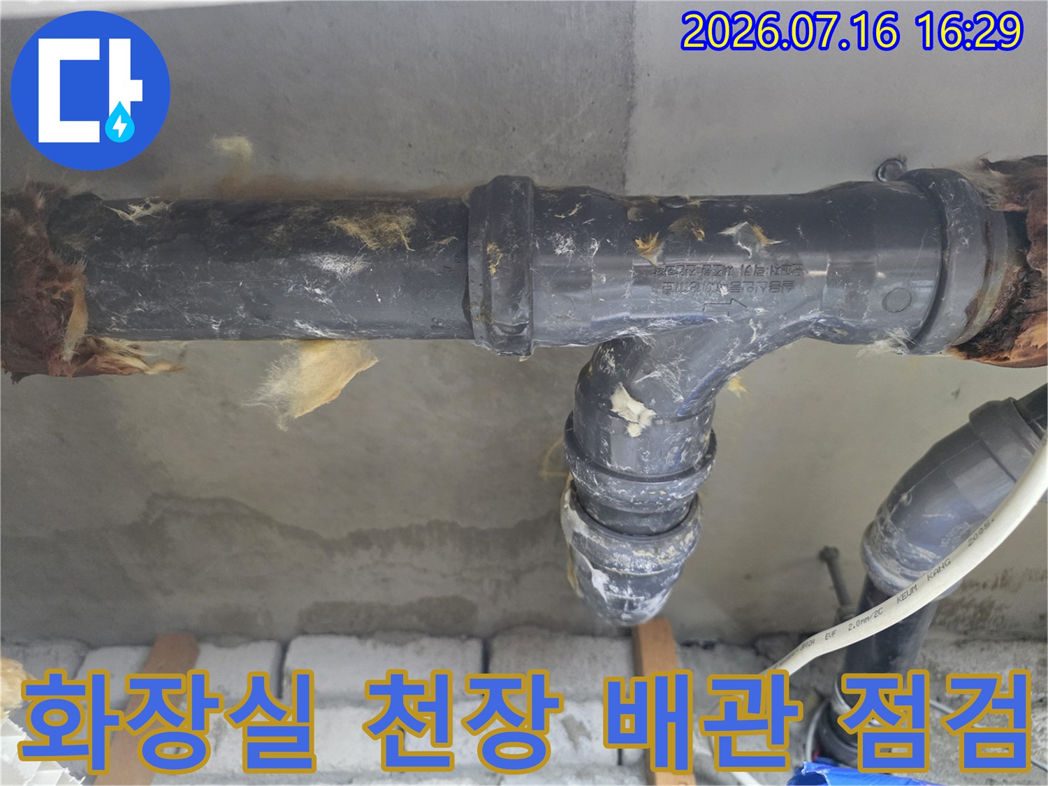 화장실 천장 안쪽의 노후된 배출용 배관과 연결 부위를 점검하는 모습
