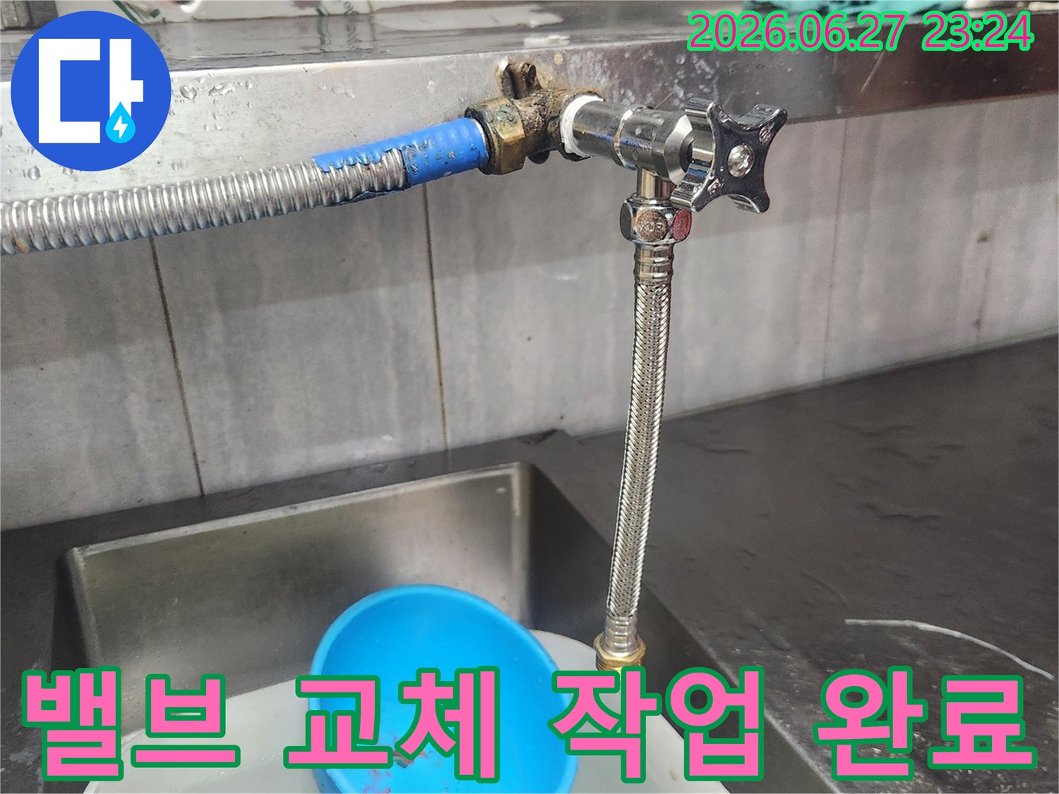 싱크대 아래 배관에서 발생한-누수를 해결하기 위해-새로운 밸브를 교체하는-전문가의 손길이 담긴 사진입니다