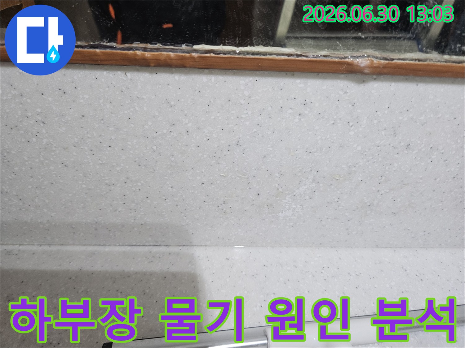 싱크대 하부장-벽면과 상판 접합부에서-관찰되는-미세한 물기 흔적을-전문적으로 분석하는 모습