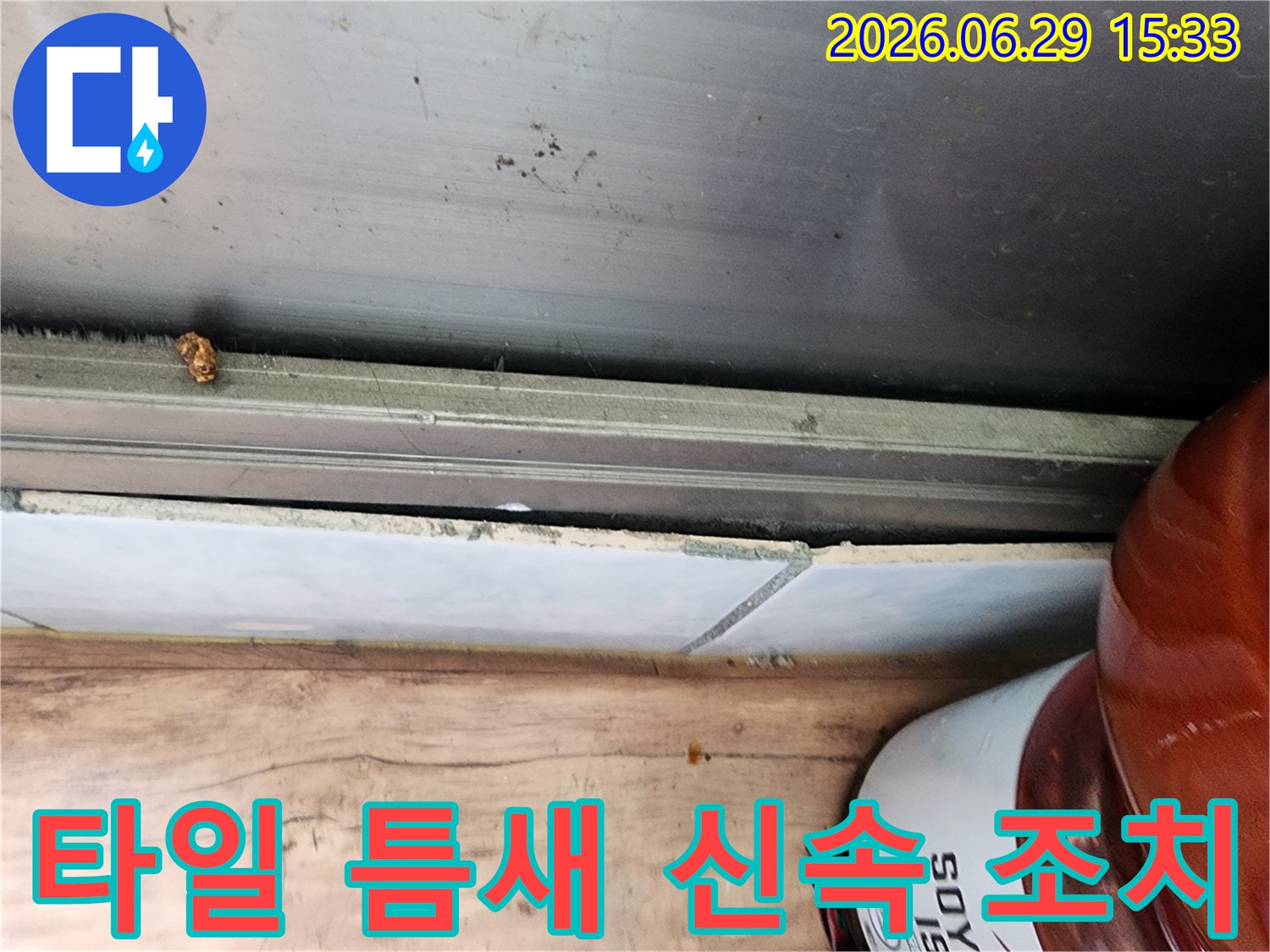 시흥 정왕동 아파트 누수 현장에서-타일 틈새에 발생한 물기로 인해-신속한 조치가 필요한 상황을 보여주는 사진입니다