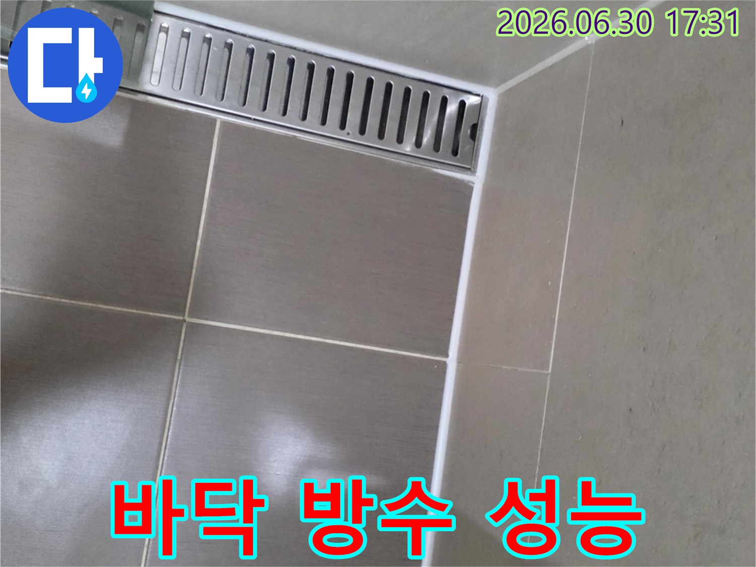욕실 바닥의-타일 이음새와-선형 배수구-주변에-새롭게 시공된-하얀색-고품질 실리콘 마감 상태를-보여주는-사진입니다.