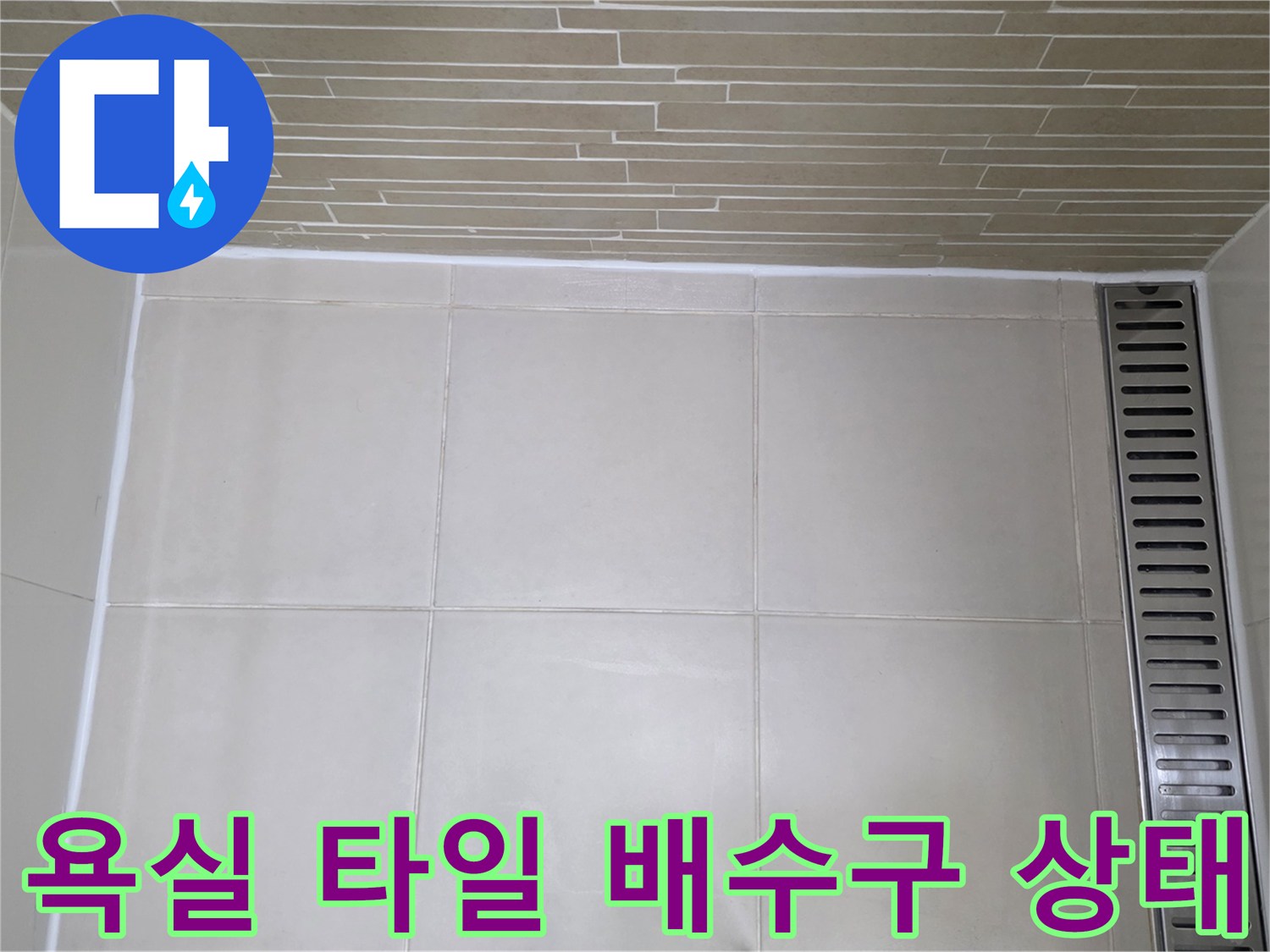 용산구 욕실-타일 줄눈과 배수 트렌치 주변 상태를 촬영한 사진입니다.