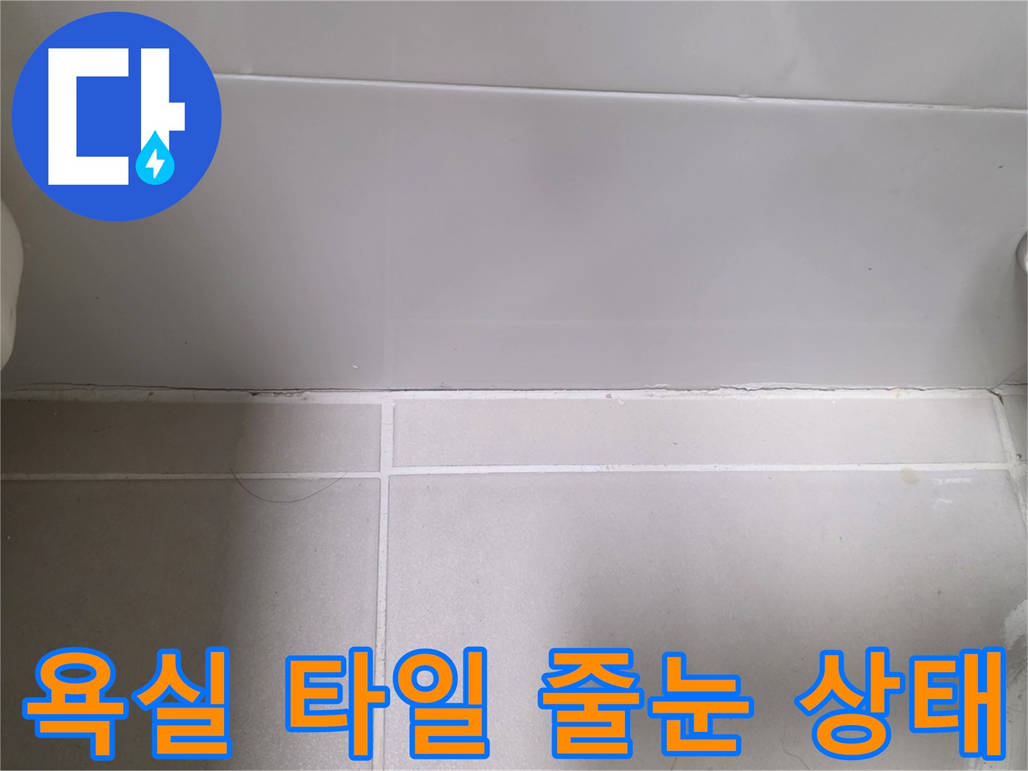 용산구 욕실의 하얀색 타일과 벽면 접합부 근처 줄눈 상태를 보여주는 사진입니다.