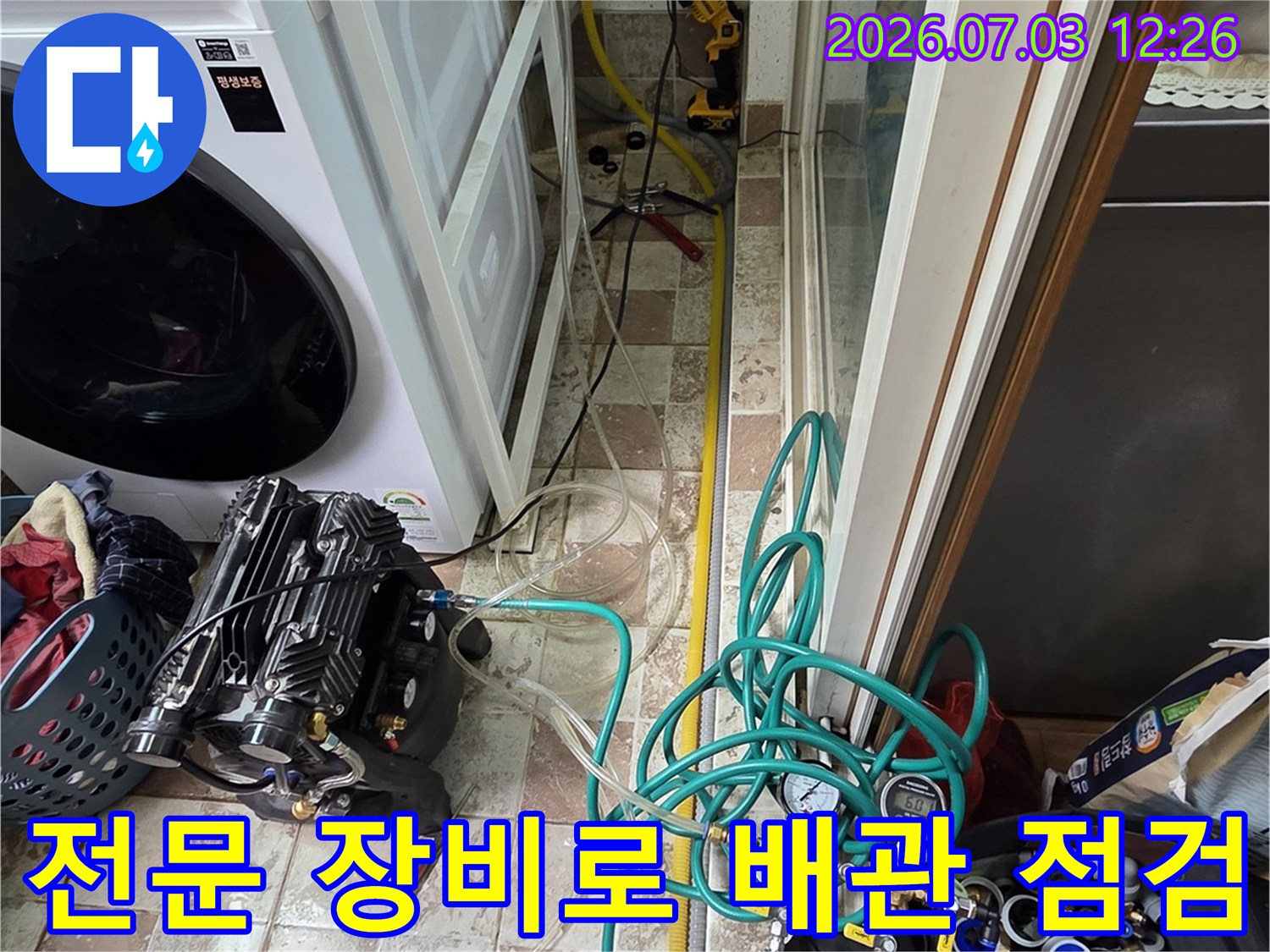 다양한 호스와 압력계가 연결된 전문 설비를 이용해 세탁실 배관을 검사하는 장면
