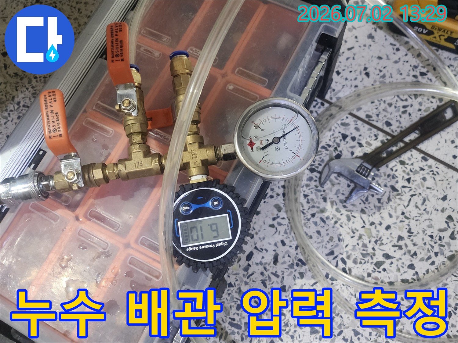 배관의 상태를 확인하고 누수 여부를 판단하기 위해 압력 게이지가 연결된 전문 장비를 사용하고 있습니다
