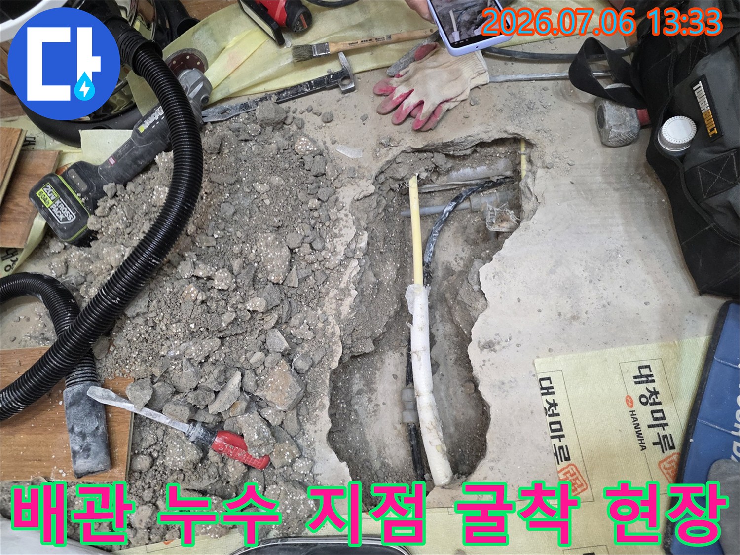 파헤쳐진 바닥 속에서 드러난 배관과 주변의 파쇄된 콘크리트