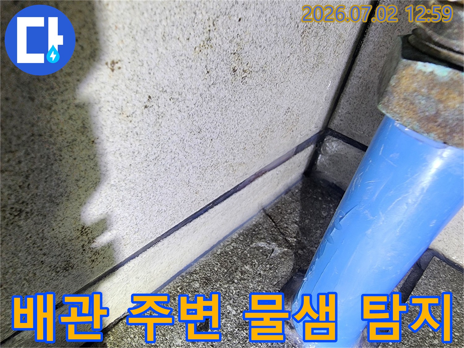 파란색-배관-주변에서-발견된-물샘-현상을-누수-전문가가-정밀하게-탐지하는-모습을-담은-사진