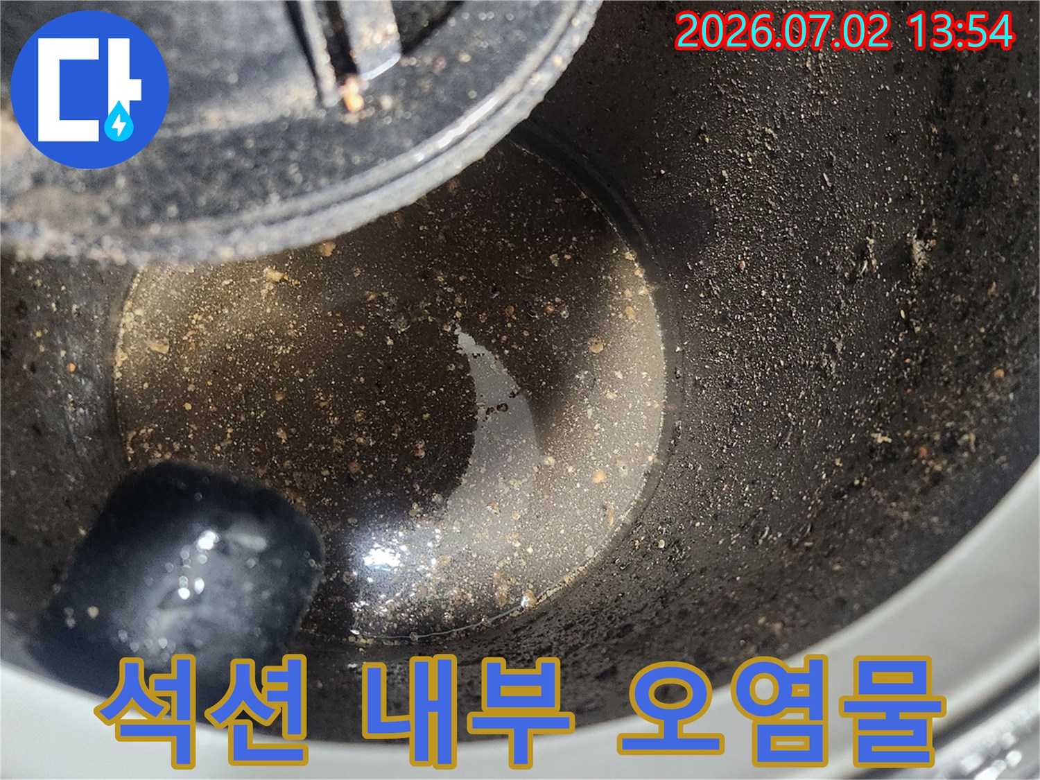 배관 스케일링 1차 작업 후-석션 장비 내부에 포집된-굳은 기름층과 오염물질을 보여주는 클로즈업 사진