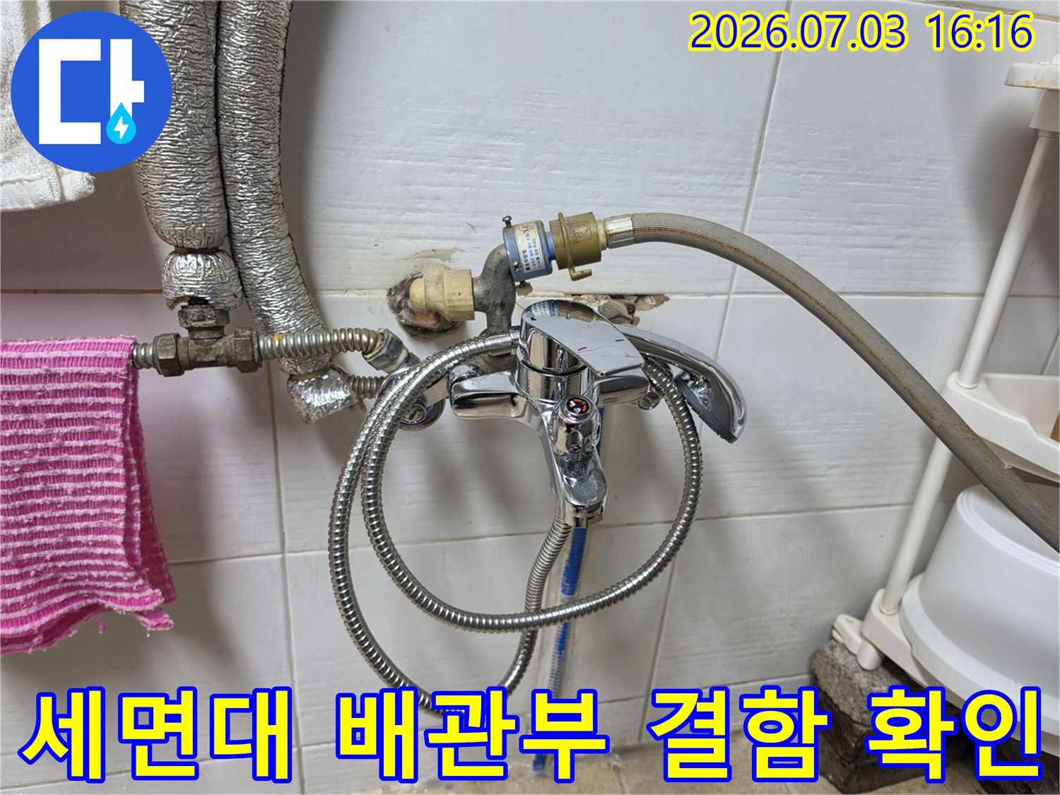세면대 하부의 복잡한 배관 연결 구조를 점검하고 누수 여부를 판단하는 장면
