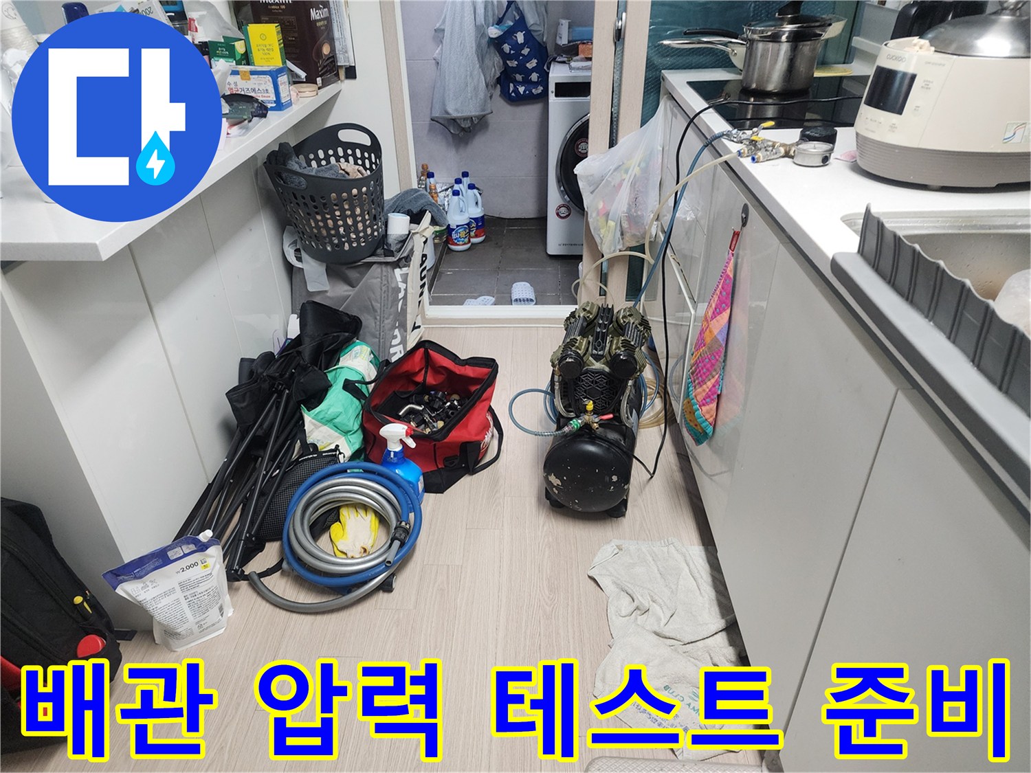 배관 내 압력을 측정하기 위해 싱크대 하부에 연결된 게이지와 호스들
