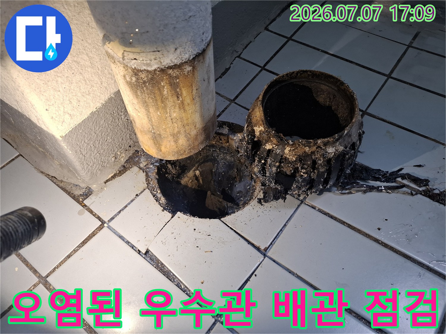 노후되어 부식된 우수관 배관과 주변의 오염된 마감재 모습