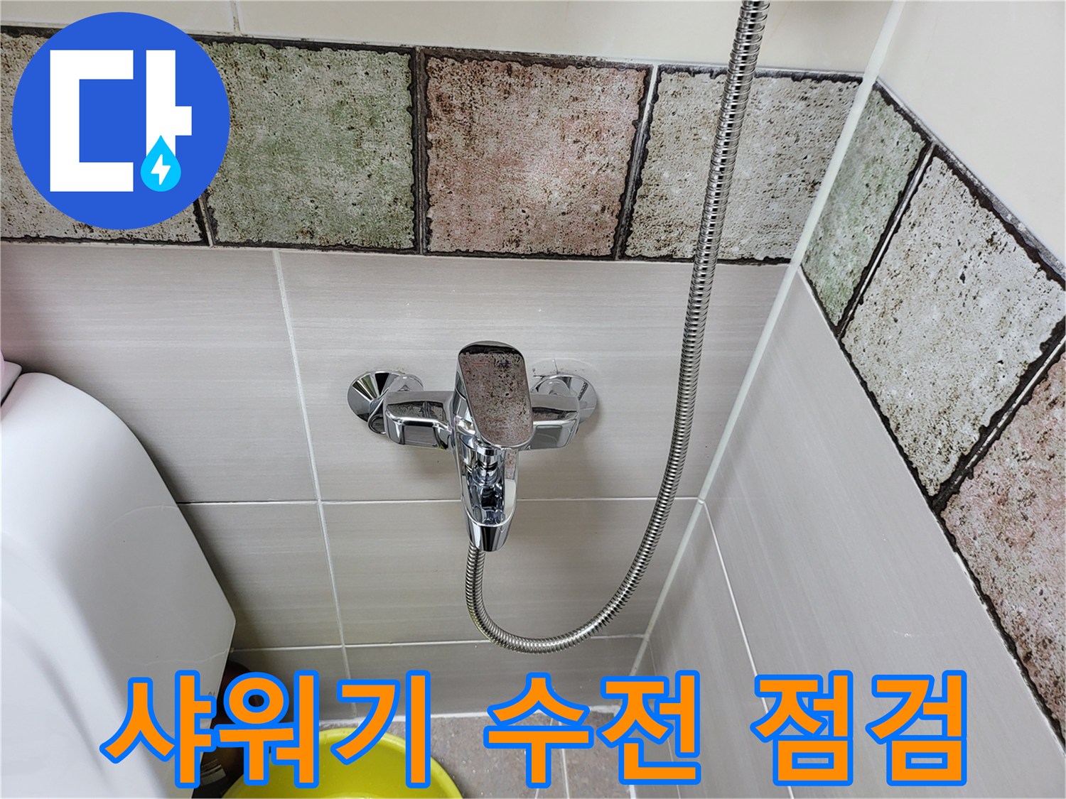 벽면 타일과 연결된 샤워기 헤드 및 수전 호스 상세 사진