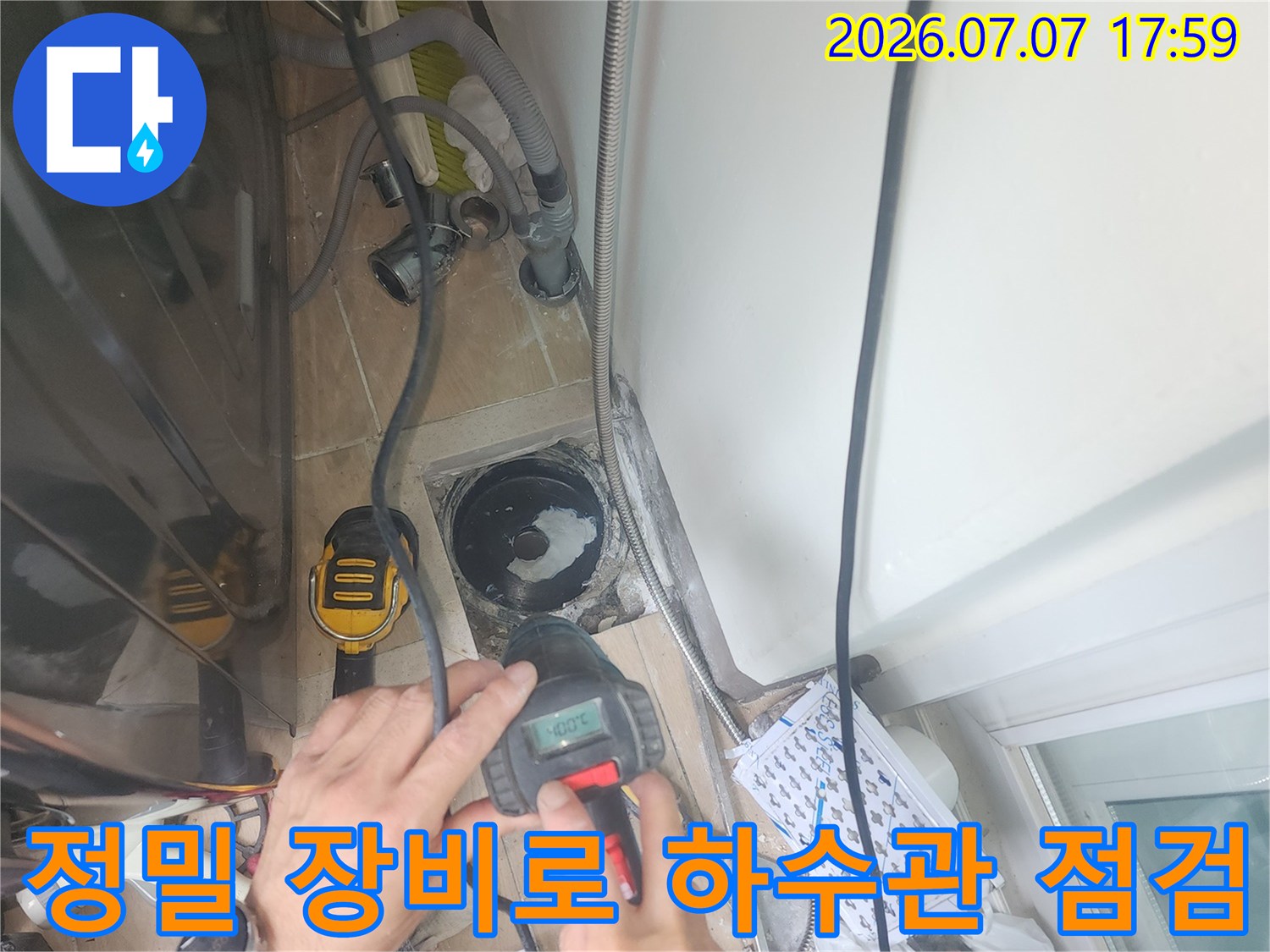 전문가용 장비를 사용하여 세탁실 배관 주변의 누수를 정밀하게 진단하는 장면