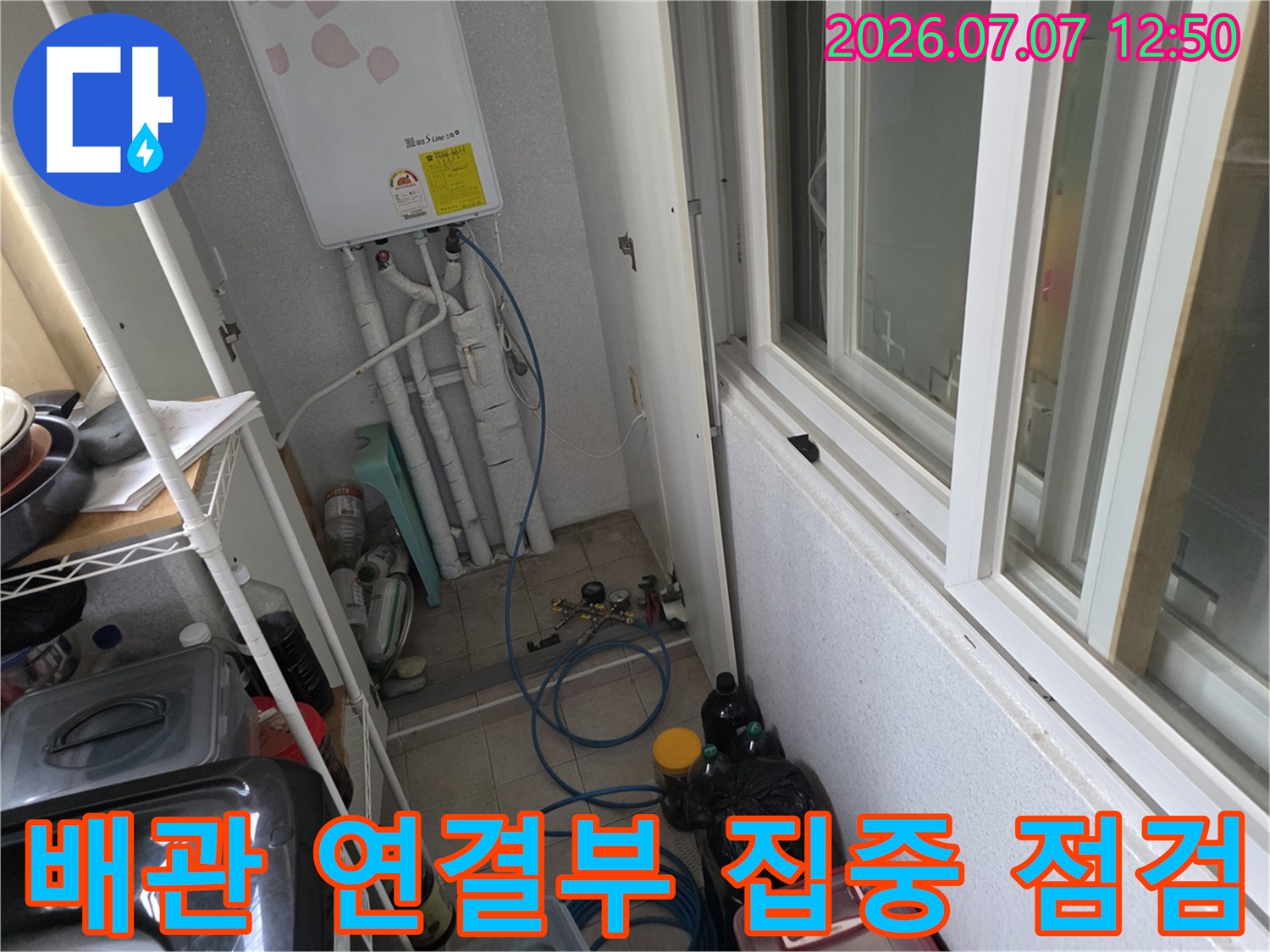 세탁실 내 설치된 배관과 호스 시스템을 정밀하게 진단하고 수리하는 모습