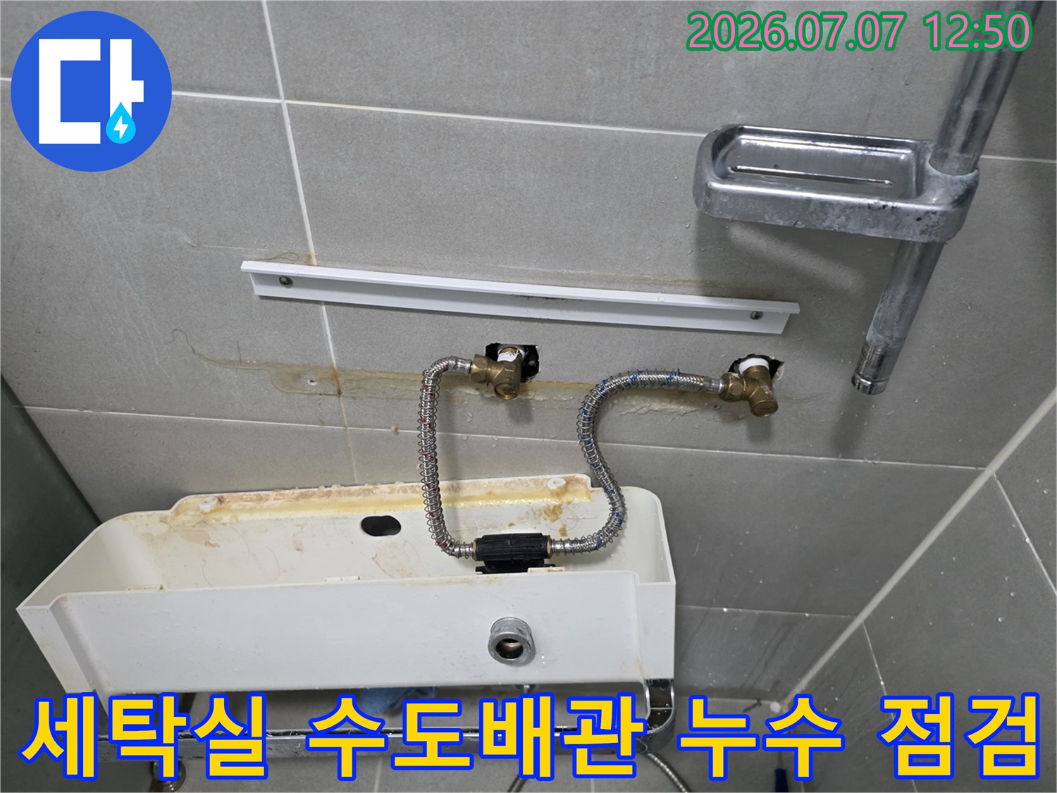세탁실 세면대 하부의 노후된 고압호스와 벽면 배관 연결 부위 점검 모습