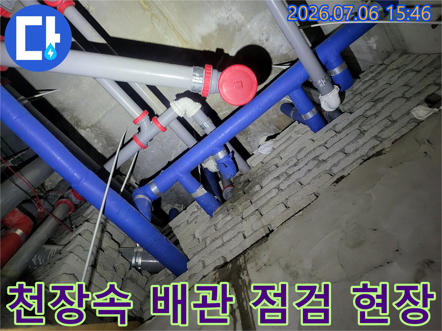 복잡한 천장 내부 파란색과 회색 배관 및 연결부 점검 모습