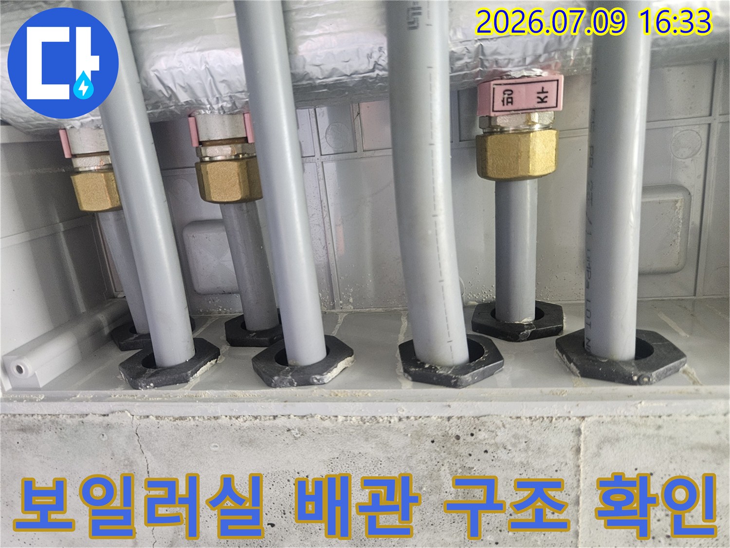 금색 밸브와 흰색 단열재로 감싸인 온수 및 급수 배관의 모습