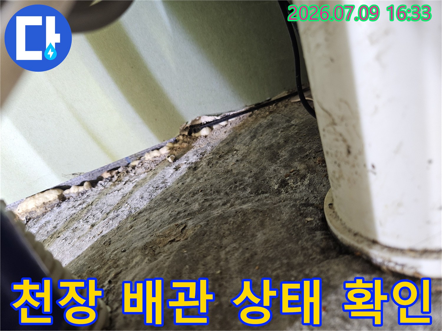 노출된 배관과 주변 마감재의 접촉면을 근접 촬영하여 누수 징후를 점검하는 모습