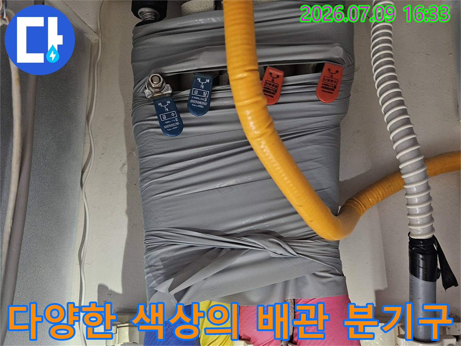 보호재로 감싼 다채로운 배관들의 연결부와 밸브가 배치된 모습