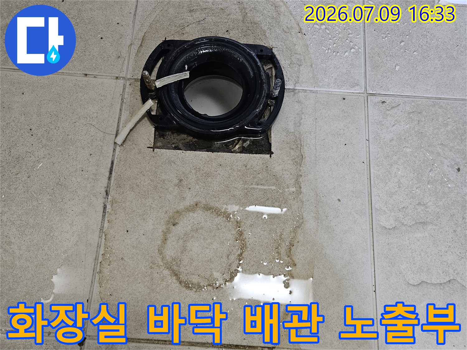 타일 제거 후 나타난 배관 연결 부분과 누수 흔적을 촬영한 사진