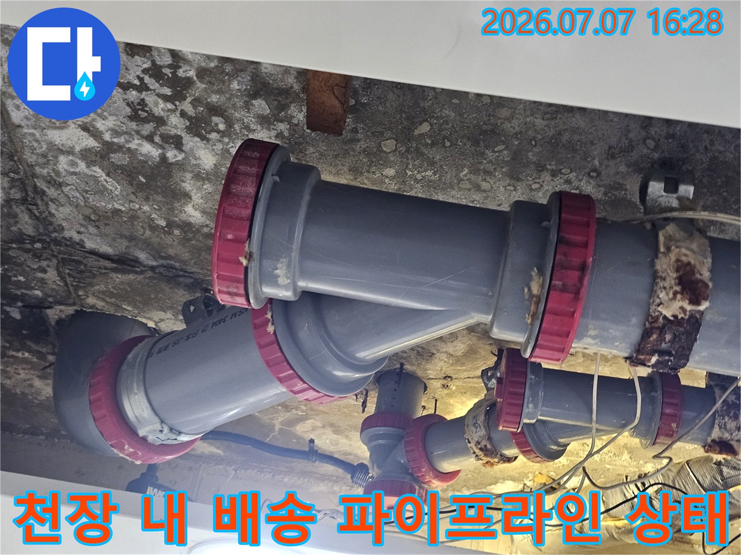 화장실 천장 내부에 설치된 복잡한 배관망과 연결 부위 점검