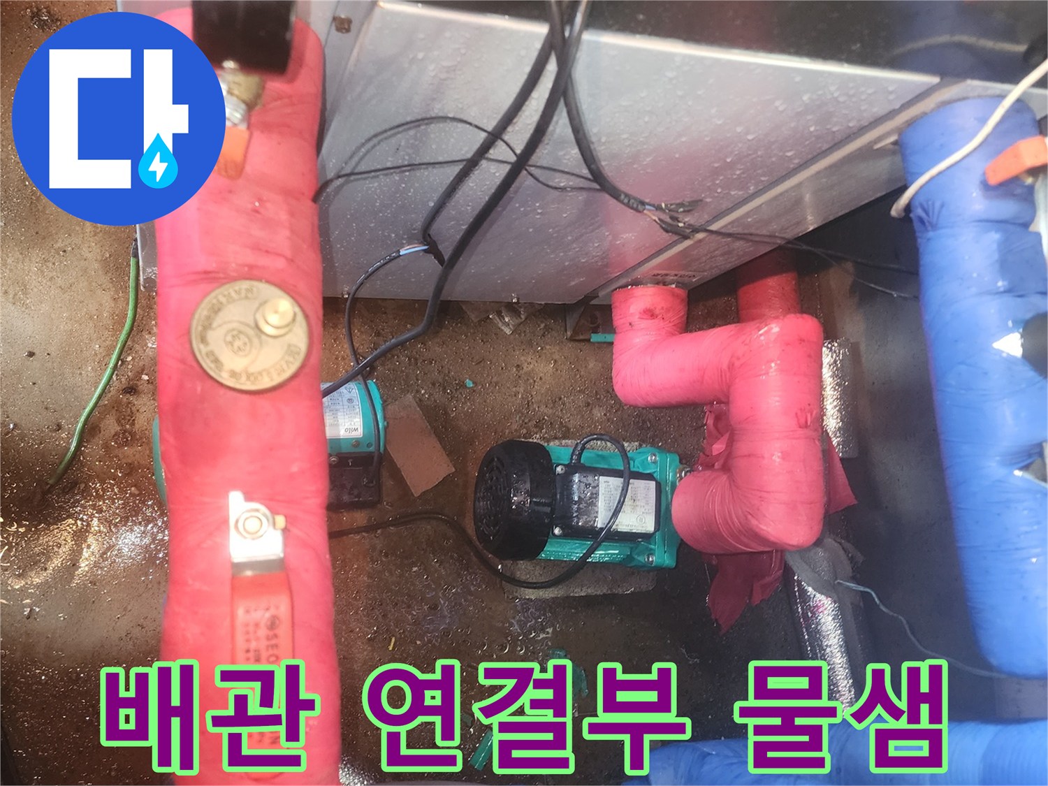 분홍색 보온재가 씌워진 배관과 노후된 펌프 장치