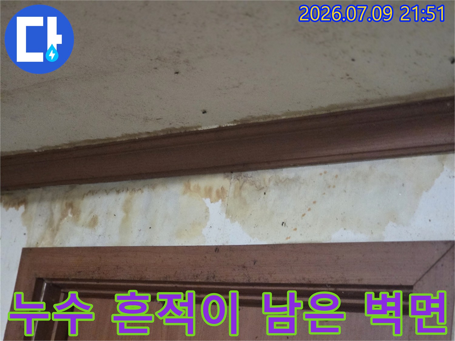 문틀 위쪽으로 누수물이 흘러 내려와 변색된 벽면 상태를 촬영한 사진