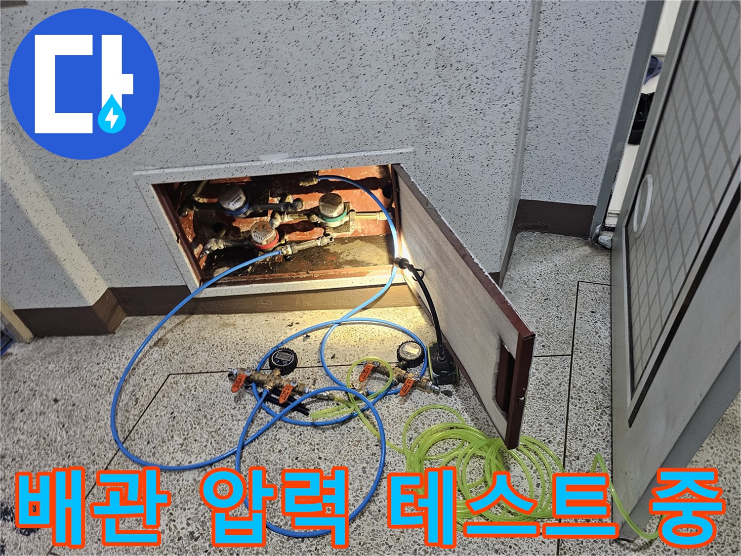 배관에 공압 장비를 연결하여 누수 여부를 확인하는 현장 사진입니다.