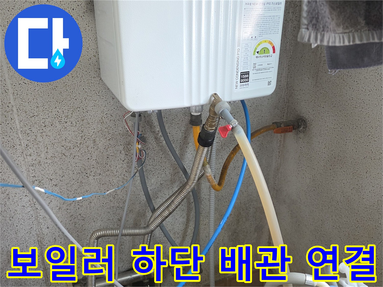 보일러 아래쪽의 복잡한 배관과 호스들이 연결된 모습