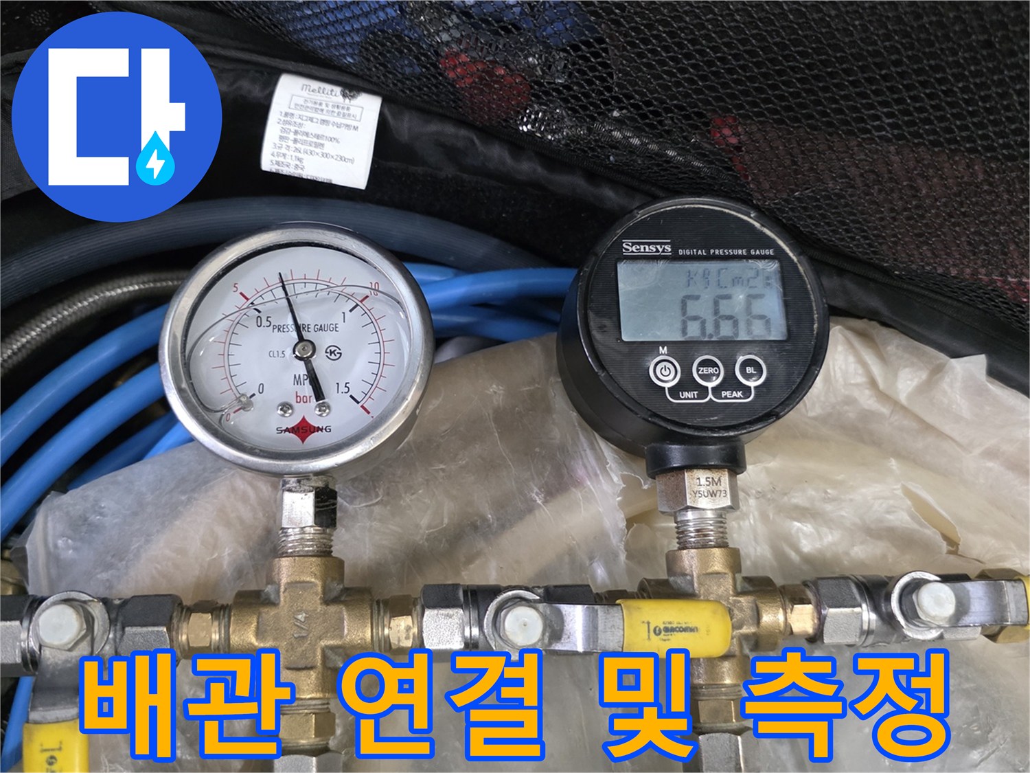 파란색 호스와 금속 피팅으로 연결된 압력 측정 장치