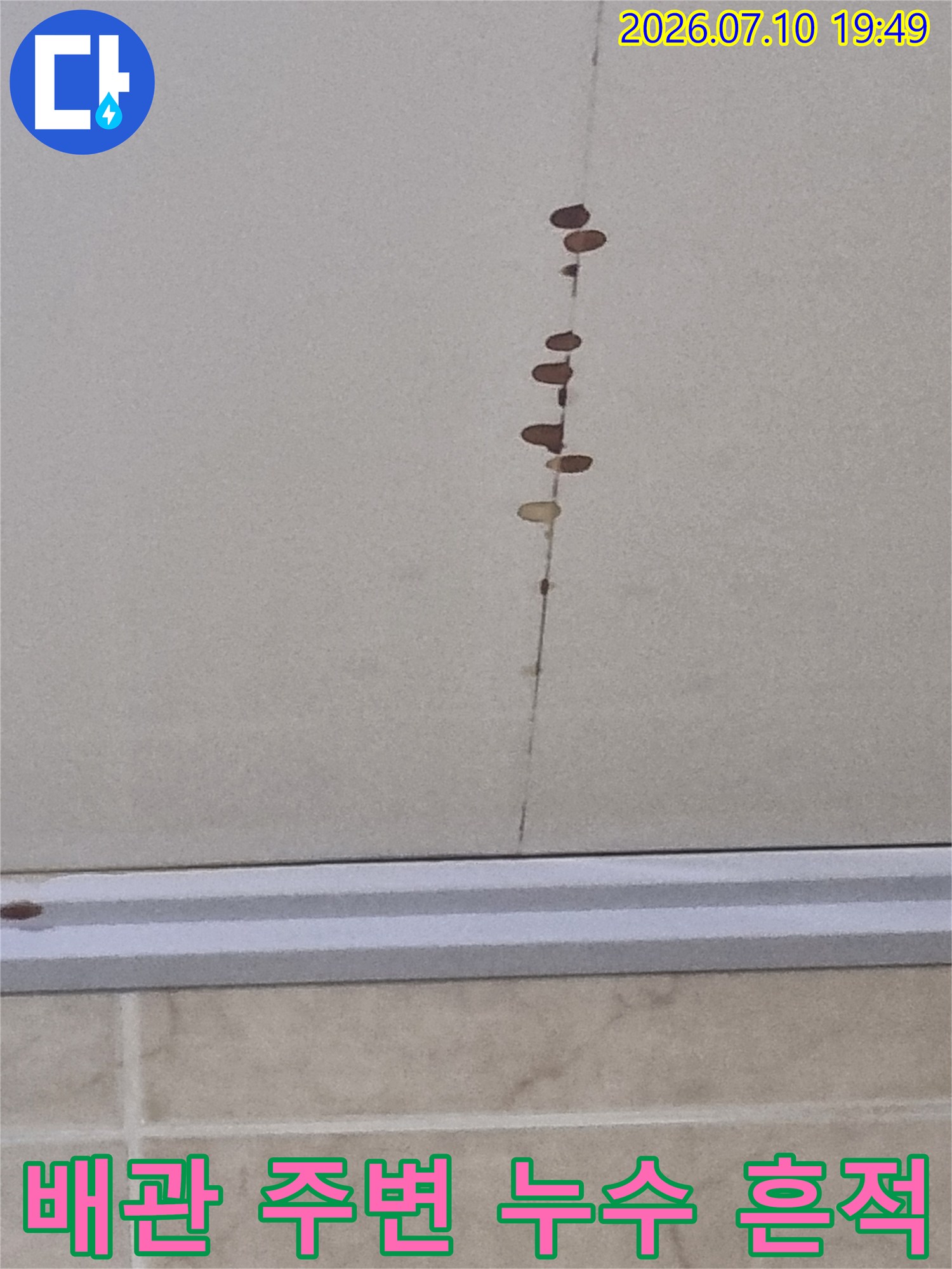 배관 노출부와 인접한 화장실 천장 마감재에 생긴 갈색 물자국