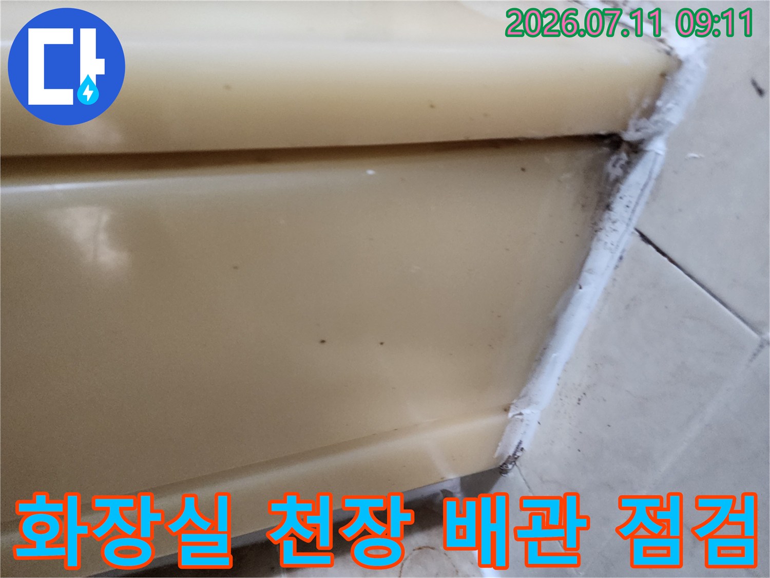화장실 천장 내부에 노출된 배관과 마감재 부근을 정밀 점검하는 모습