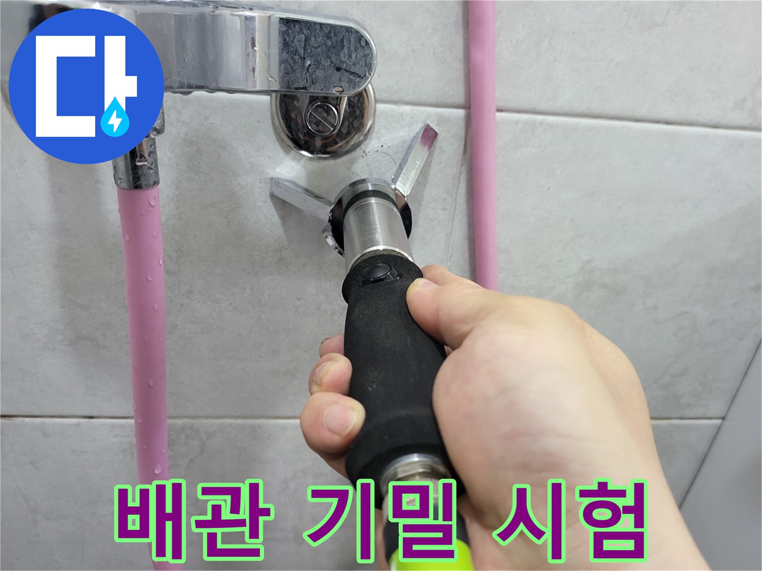 수도 밸브 부근에 압력 측정 장비를 연결하여 배관의 기밀성을 점검하고 있습니다.