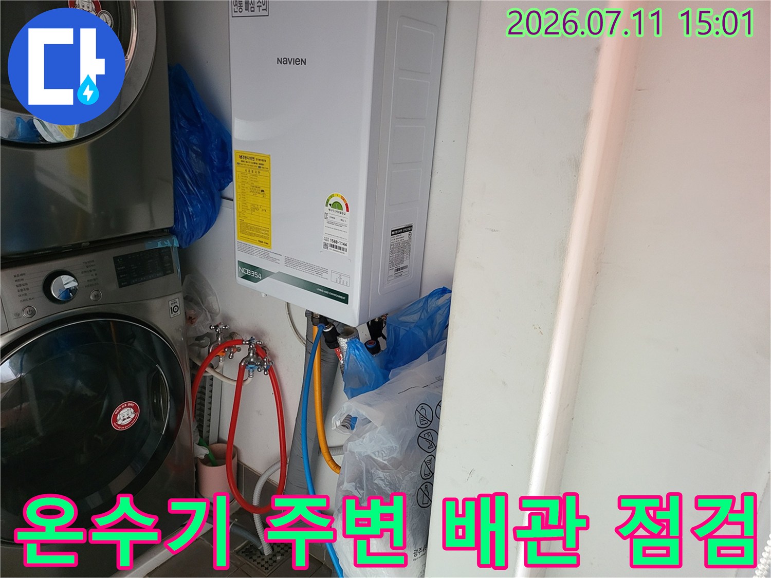 온수기와 연결된 배관부의 누수 여부를 점검하는 장면