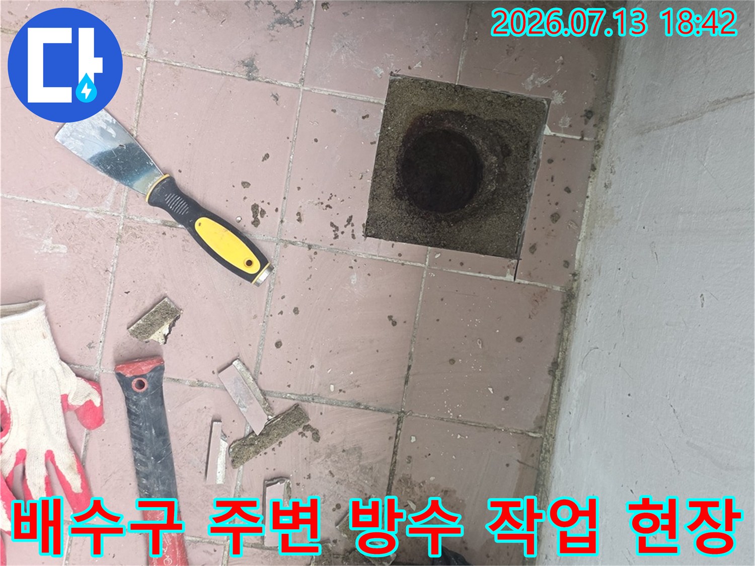 배수구 주변 타일과 배관을 점검하는 도구와 장비들이 배치된 현장 사진