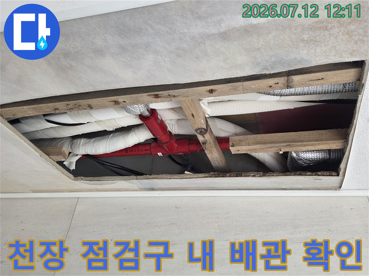 천장 점검구를 통해 노출된 빨간색 소방 배관과 하얀색 설비 배관의 모습