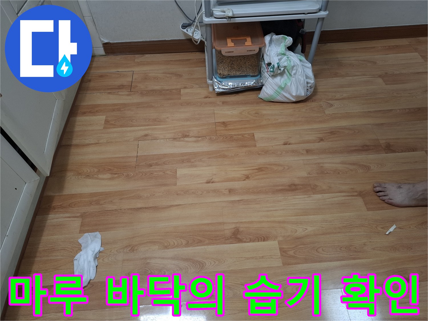 누수 지점을 찾기 위해 관찰 중인 주방 마루 사진
