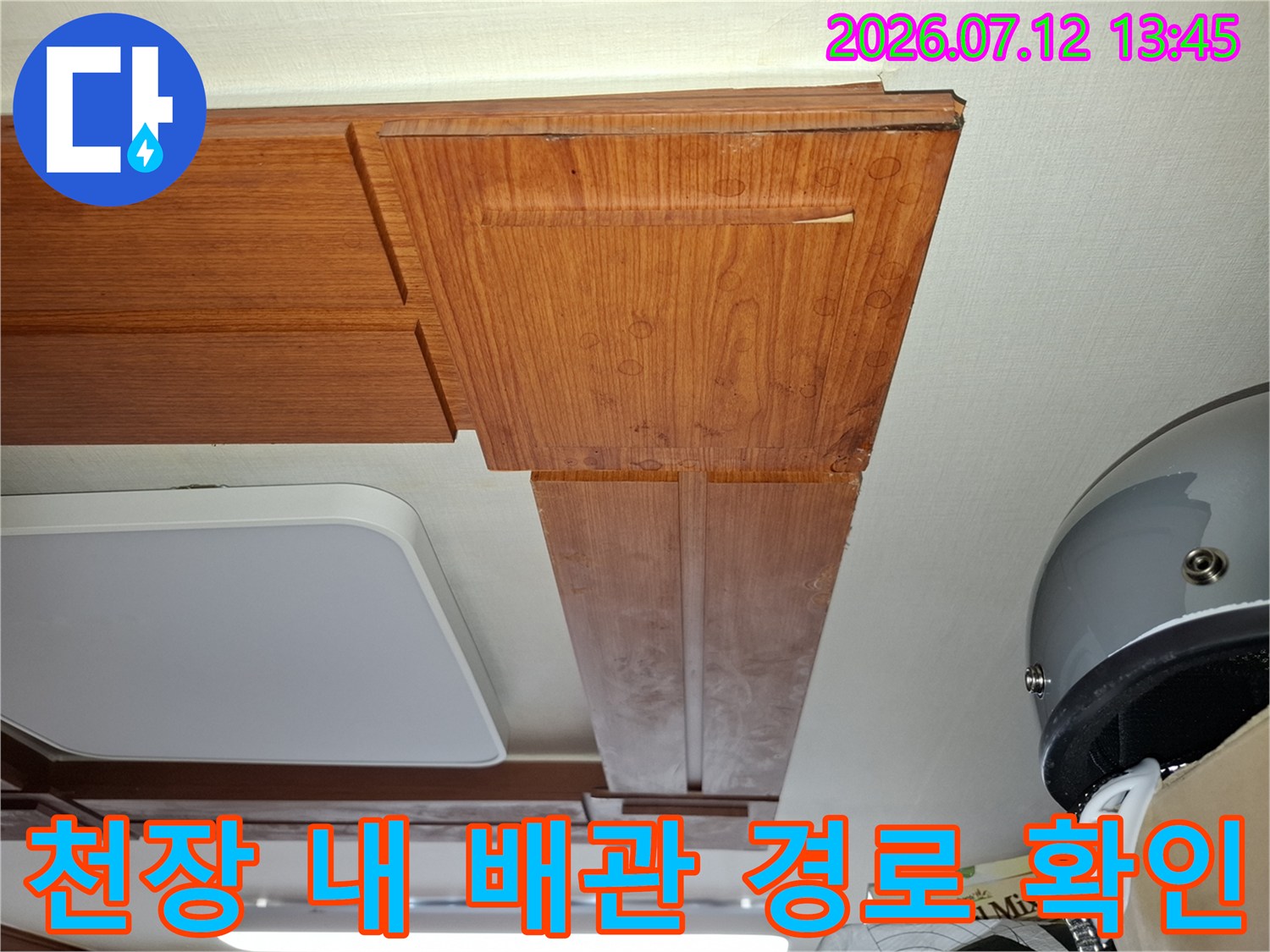 상부 천장 마감재 사이로 노출된 공간과 배관 구조물