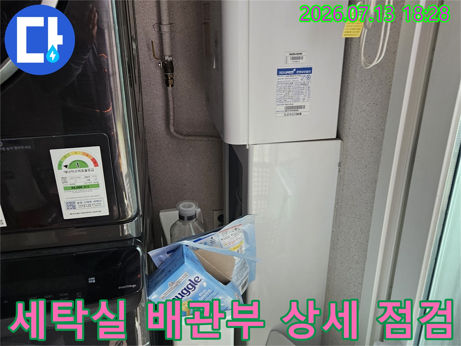 세탁 공간 내 노출된 배관과 연결 구성품들에 대한 정밀한 육안 검사 장면
