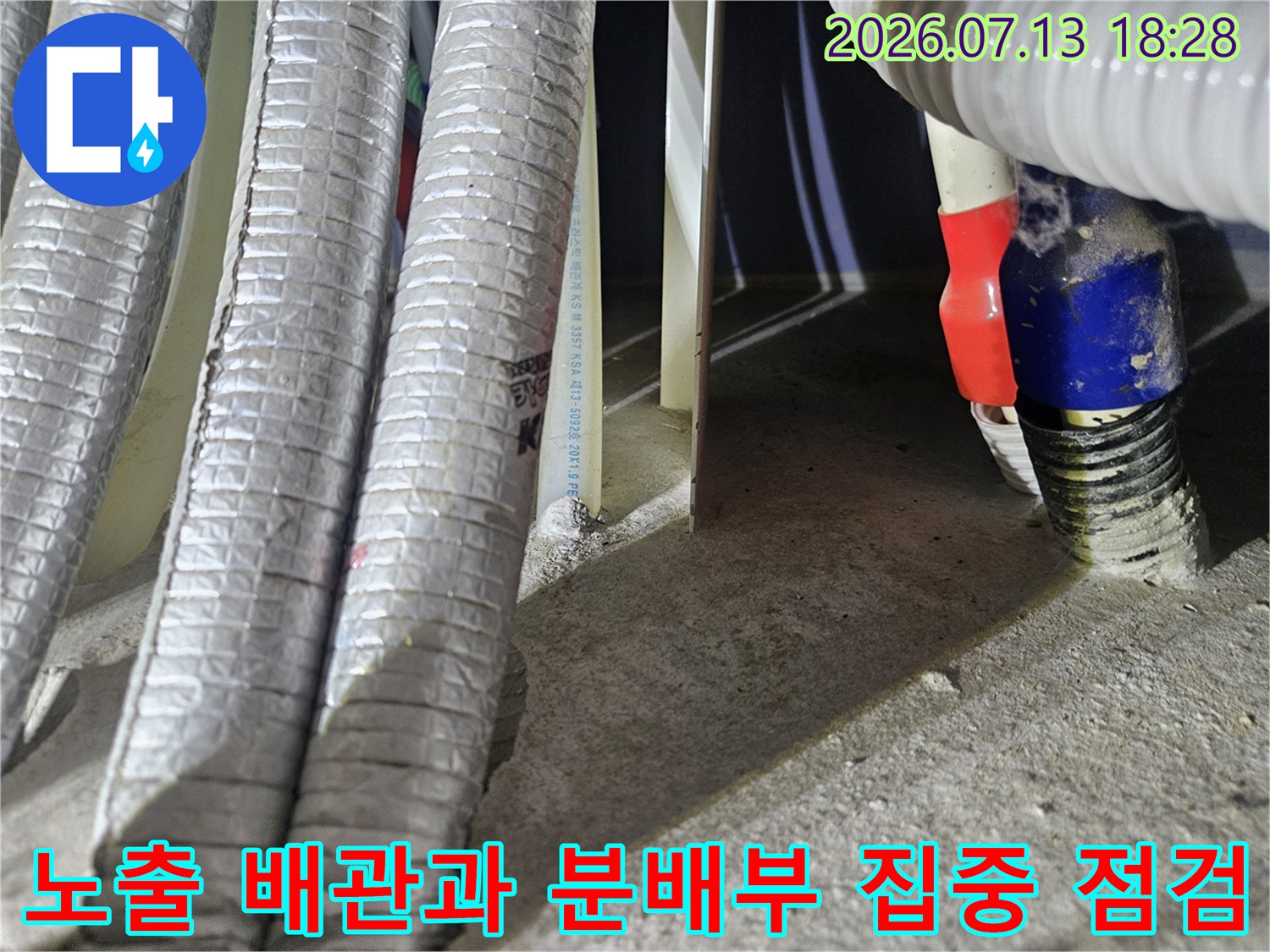 은색 보온재로 감싸진 노출 배관들과 파란색 밴드로 고정된 연결 부위 모습
