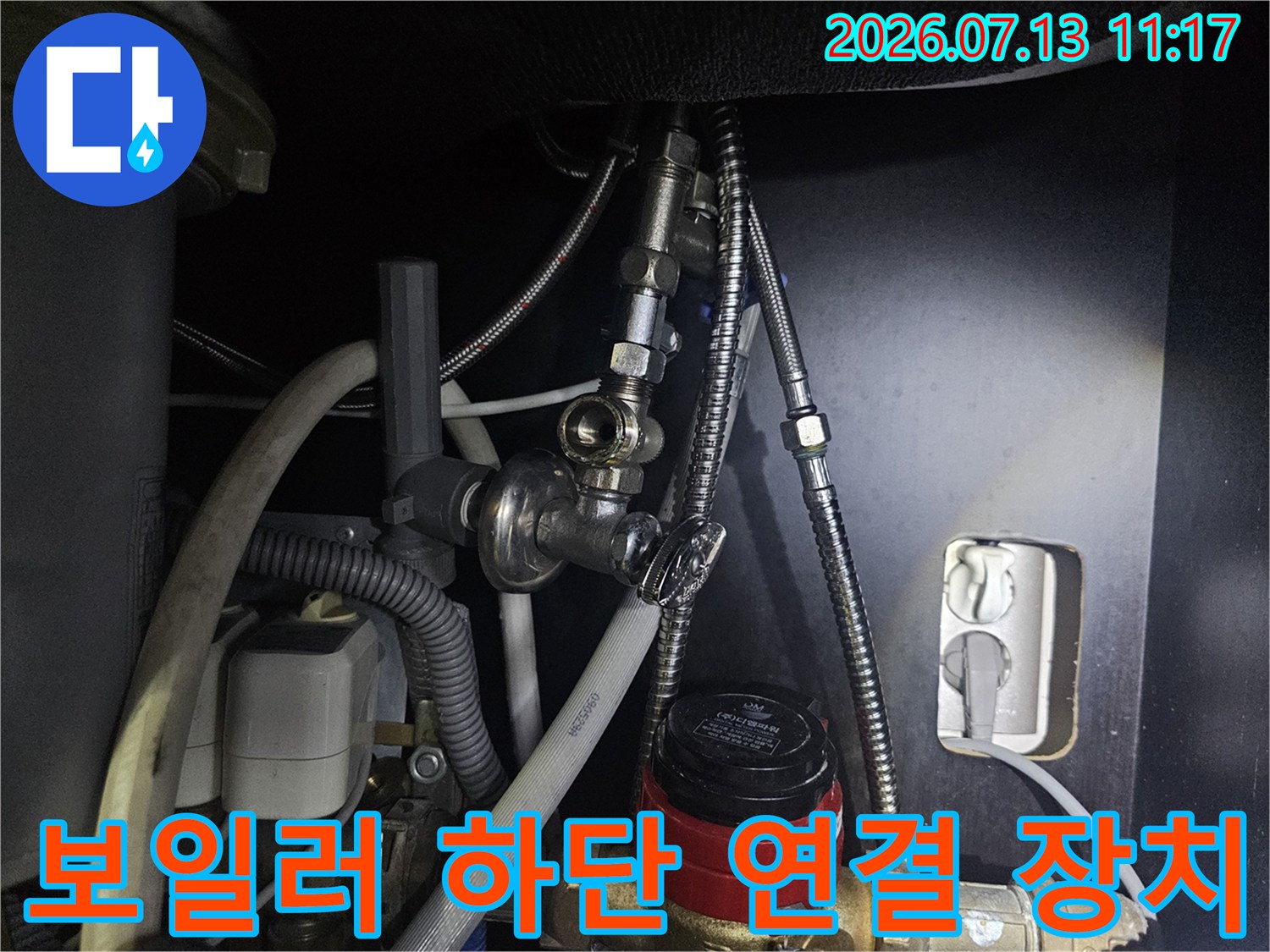 금속제 유연 주름 배관과 빨간색 핸들이 달린 밸브의 배치 모습-사진
