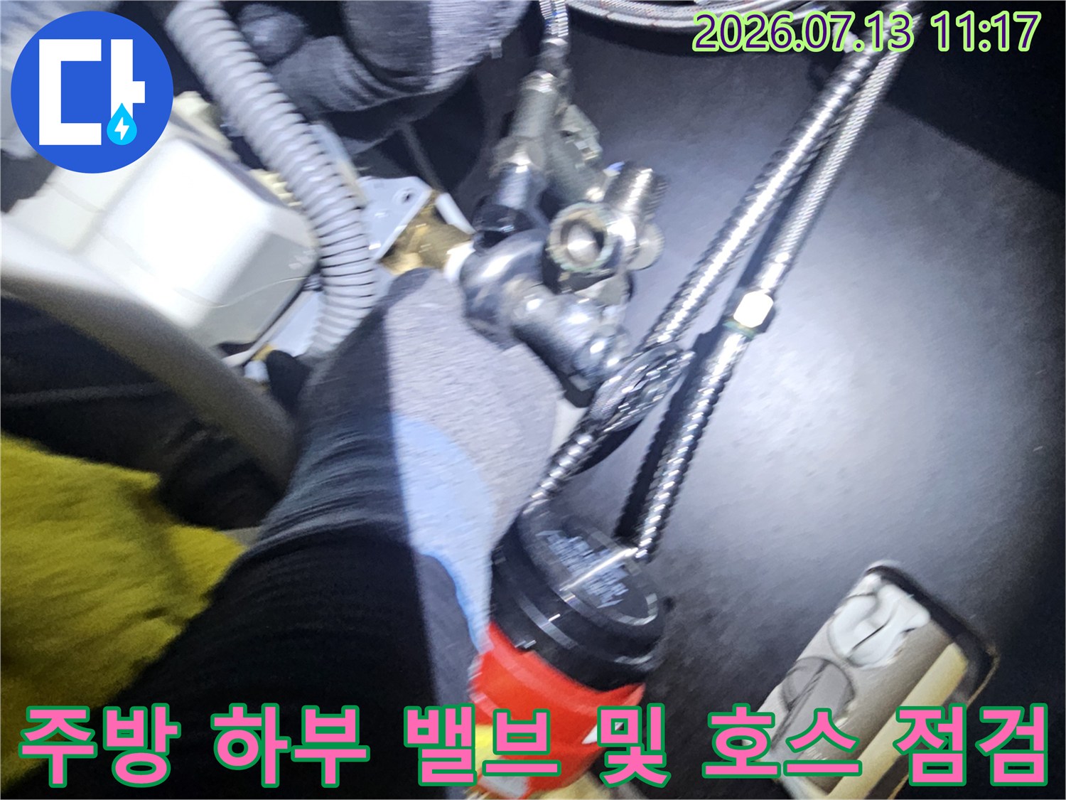 금속제 주름관-밸브-연결 부품들이 설치된 싱크대 내부 사진