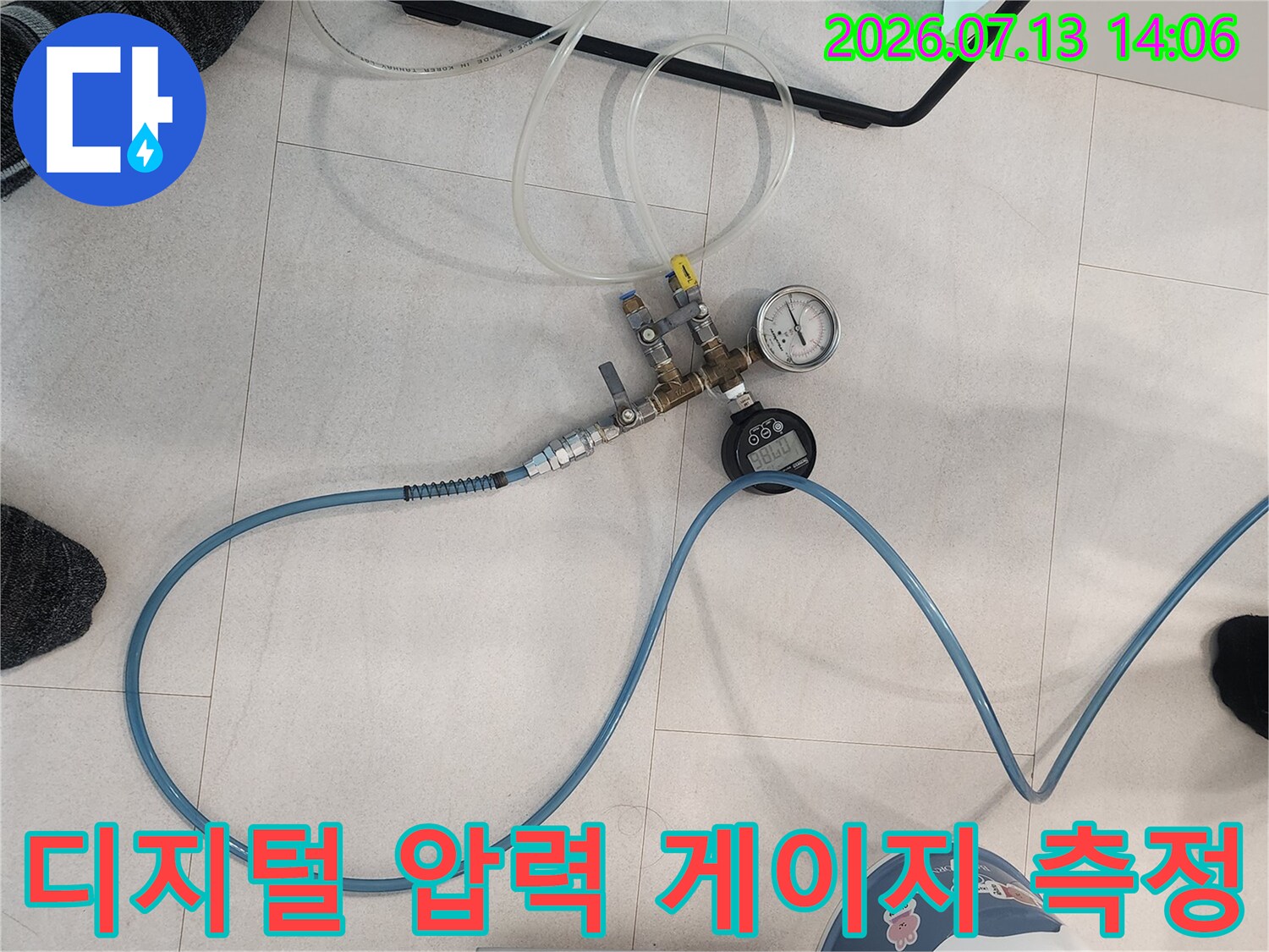 누수 탐지를 위해 연결된 파란색 고무 호스와 정밀 압력 측정기