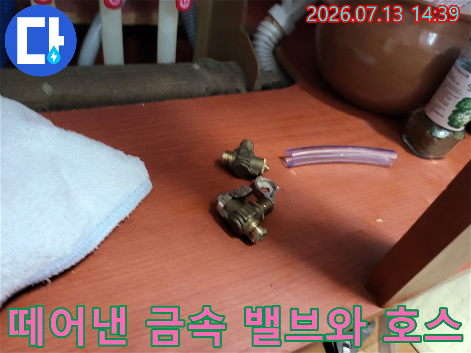 노후되어 누수가 발생한-금속제 수도 밸브와 투명 플라스틱 호스